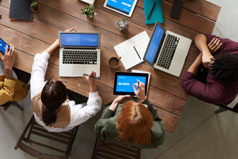 overhead view of office workers and laptops